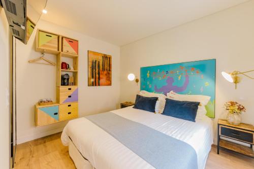 een slaapkamer met een groot wit bed met blauwe kussens bij Bairro Alto Music Guest House in Lissabon