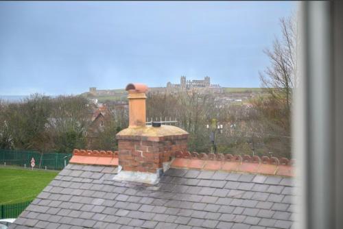 a house with a brick chimney on top of a roof at Coast Guest House in Whitby