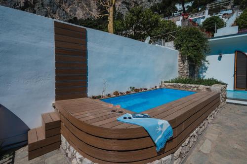 una piscina con terraza de madera y una piscina en Villa La Baika - Pool Panoramic views, en Capri
