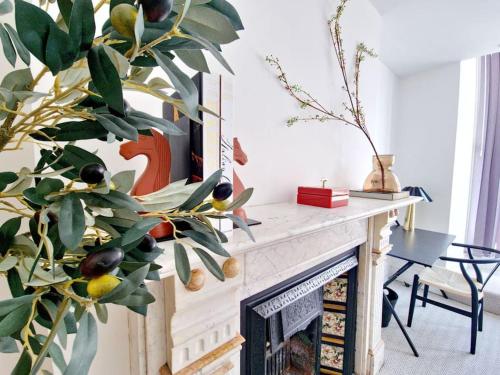 a living room with a fireplace with a plant at The Stray adjacent, Interior-Designed 2-bed Apartment- Luxury in Harrogate