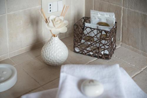 un vaso bianco con un fiore in bagno di Dimora Fra' Giovanni B&B Relais a Magione