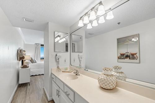 a white bathroom with a sink and a mirror at Phoenix 6 Unit 706 in Orange Beach