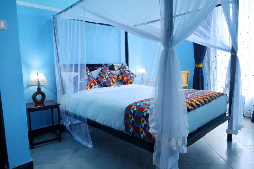 a bedroom with a bed with a canopy at ESCAPE VILLAGE HOTEL in Yumbe