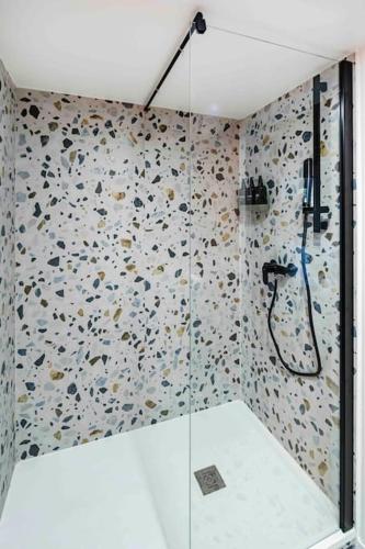 une douche avec une porte vitrée dans une salle de bain dans l'établissement Pavillon Eden « L’Écrin », à Paris