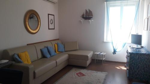 ein Wohnzimmer mit einem Sofa und einem Spiegel in der Unterkunft Viale Dante in Grado