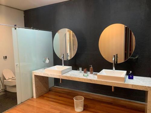 uma casa de banho com dois lavatórios e dois espelhos em Orla Villas Brasília em Rio Bananal