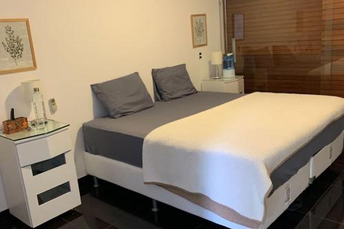 um quarto com uma cama grande e uma mesa de cabeceira em Orla Villas Brasília em Rio Bananal