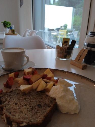 a plate of food with bread and fruit on a table at Casa Vittoria Guest House in Romano D'Ezzelino