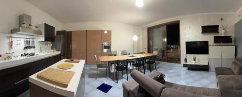 una cucina e un soggiorno con tavolo e sedie di Roof Apartment a Somma Vesuviana