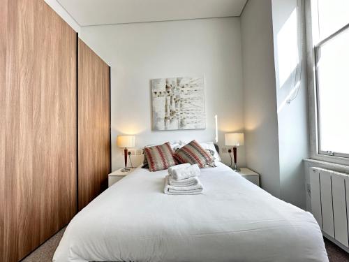 - une chambre avec un grand lit blanc et deux lampes dans l'établissement Chic apartment in Queensway for six guests, à Londres