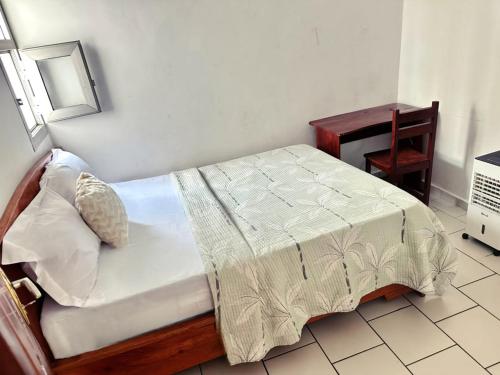 a bedroom with a bed with a table and a chair at GOLF HILLS BASTOS in Yaoundé