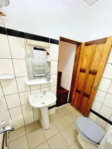 a bathroom with a toilet and a sink at GOLF HILLS BASTOS in Yaoundé