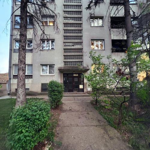 an apartment building with a sidewalk in front of it at Sunny Apartment in Kragujevac