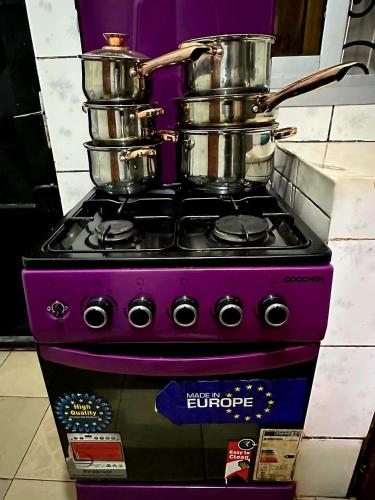 a purple stove with pots and pans on top of it at GOLF HILLS BASTOS in Yaoundé