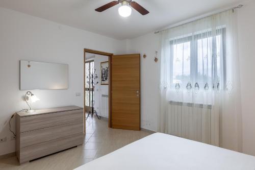 Un dormitorio con una cama y un ventilador de techo. en Ca' Graziosi Cuori, en Bagnone