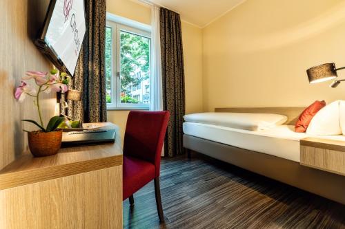 una camera d'albergo con letto e scrivania di CityClass Hotel am Heumarkt a Colonia