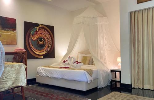 1 dormitorio con 1 cama con dosel en OASIS VILLA Suites & Rooms, en Karon Beach