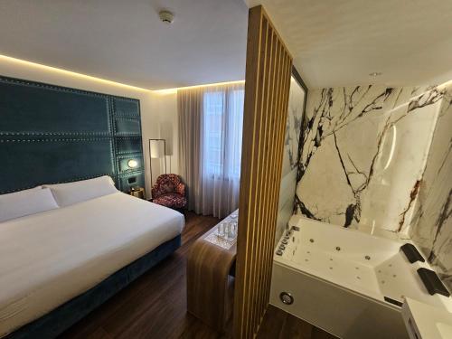 a hotel room with a bed and a mirror at Hotel Las Tres Campanas in Badajoz