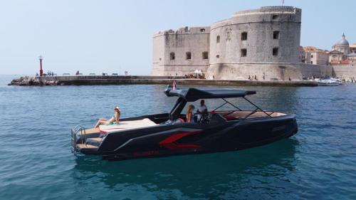 a boat in the water in front of a castle at RAPTOR in Dubrovnik