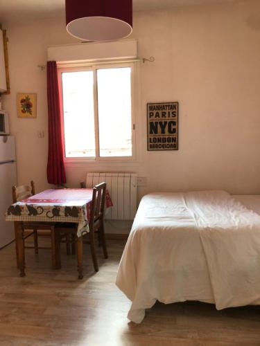 a bedroom with a bed and a table and a window at Résidence Natura in Ax-les-Thermes