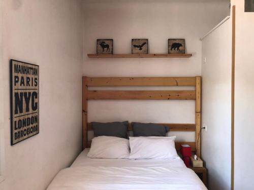 um quarto com uma cama e uma cabeceira em madeira em Résidence Natura em Ax-les-Thermes