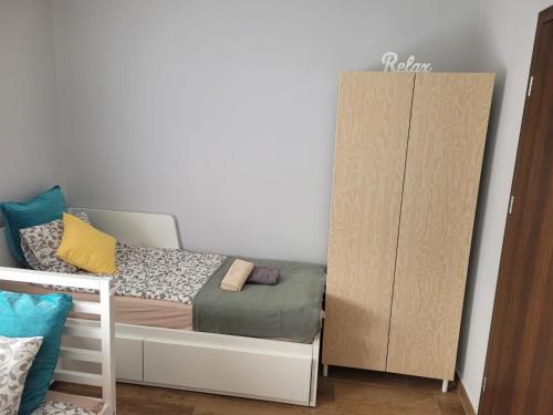 a small bedroom with a bed and a cabinet at Grey House in Wrocław