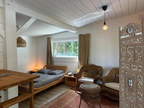 een slaapkamer met een bed en een tafel en stoelen bij Appartement indépendant Guethary in Saint-Jean-de-Luz