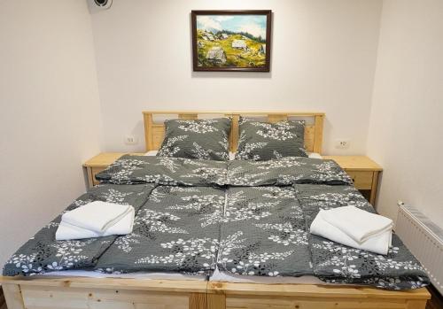 a bed with black and white sheets and pillows at Apartment Pr'pek in Bohinj