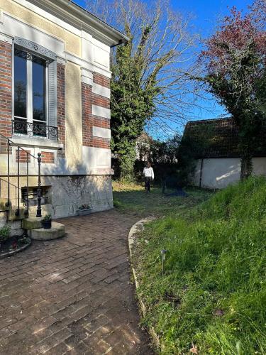 a person standing outside of a house at Maison spacieuse à Saint-Florentin, 138 m², avec jardin in Saint-Florentin
