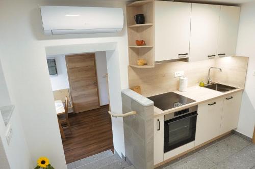 a kitchen with white cabinets and a sink at Apartment Pr'pek in Bohinj