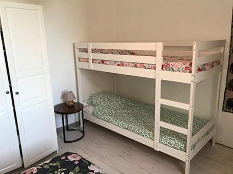 une chambre avec deux lits superposés et une table dans l'établissement Résidence méditerranéenne, piscine, jardin pour 6 personnes, à Roujan