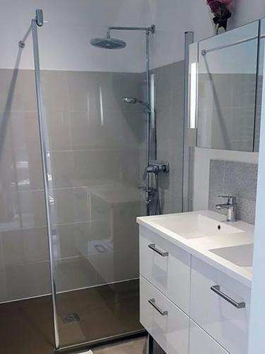 une salle de bain avec une douche en verre et un lavabo dans l'établissement Résidence méditerranéenne, piscine, jardin pour 6 personnes, à Roujan