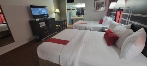 a hotel room with two beds and a television at Ramada by Wyndham Mountain Home in Mountain Home