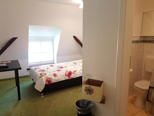 ein kleines Schlafzimmer mit einem Bett und einem Badezimmer in der Unterkunft Hotel Fauna in Breiholz