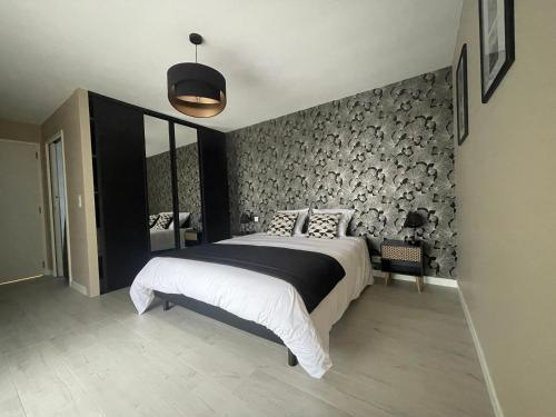 a bedroom with a large bed with a wall covered in logs at Villa avec piscine, à 5 minutes de la plage. Idéal pour vacances en famille et amis in Plouhinec