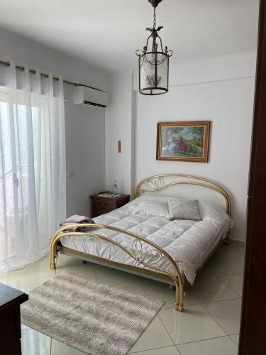 een slaapkamer met een bed en een kroonluchter bij Small City living HB in Vlorë