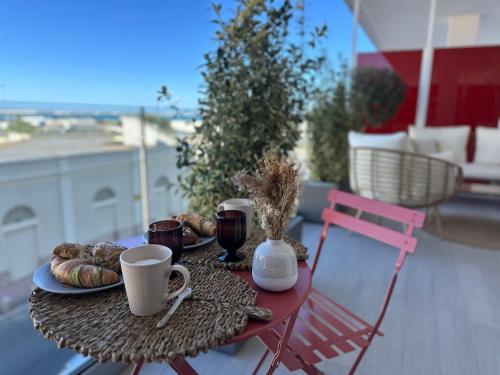 a table with a breakfast of coffee and croissants at Azuma Luxury Home in Bari