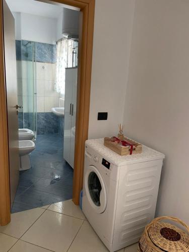 een wasmachine in een badkamer met een toilet bij Small City living HB in Vlorë