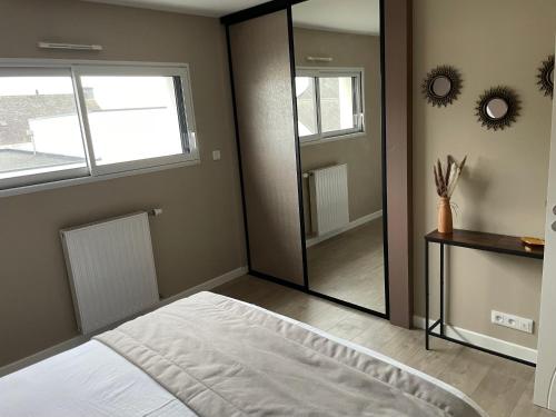 a bedroom with a large mirror and a bed at Villa avec piscine, à 5 minutes de la plage. Idéal pour vacances en famille et amis in Plouhinec
