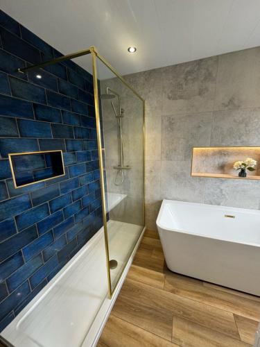 uma casa de banho com um chuveiro, uma banheira e um lavatório. em Chequers Inn em Harrogate