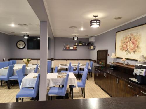 a dining room with tables and blue chairs at Pensiunea Vila Chesa in Corunca