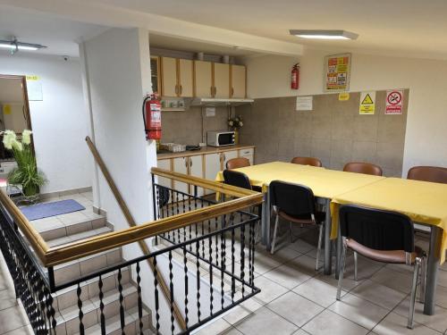 a dining room with a yellow table and chairs at Pensiunea Vila Chesa in Corunca