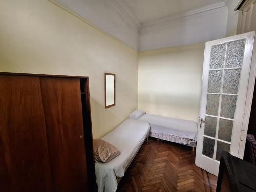 a small room with two beds and a door at Aires de Tango Hostel in Buenos Aires