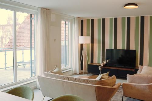 a living room with a couch and a television at 21rooms Apartments in Ingolstadt