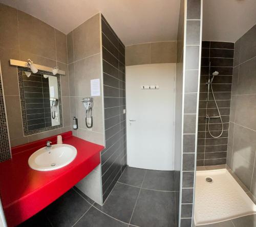 a bathroom with a sink and a shower at Hotel Mendy in Saint-Jean-le-Vieux