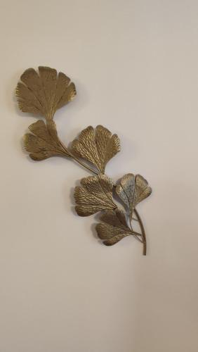 a metal leaf wall decoration on a white background at Apartament Reja in Włocławek