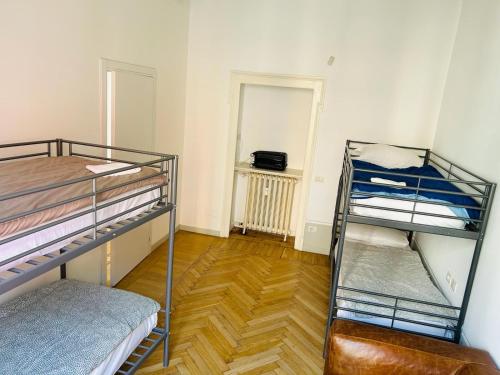 a room with two bunk beds and a wooden floor at Maya Rooms in Milan
