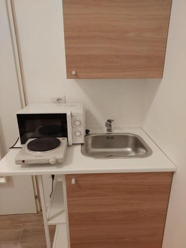 a kitchen counter with a microwave and a sink at Residence e appartamenti Bausan in Naples