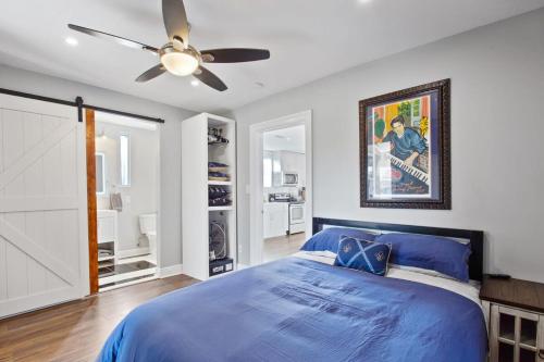 a bedroom with a blue bed and a ceiling fan at Spectacular Roof Top Deck - Luxury 3 bedroom in New Orleans