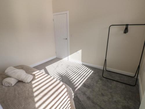 a room with a bed with sunlight shining on the floor at Wychwood in Haverfordwest